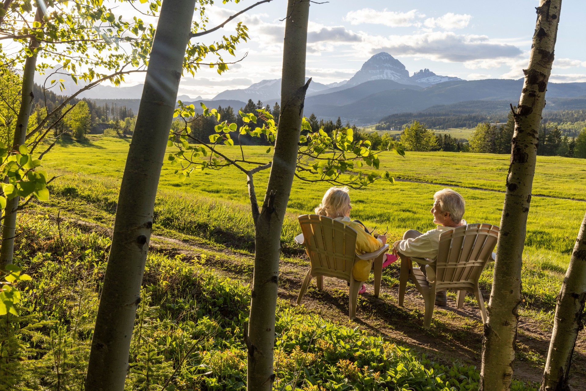 Senior couple relax in chairs in rural landscape
